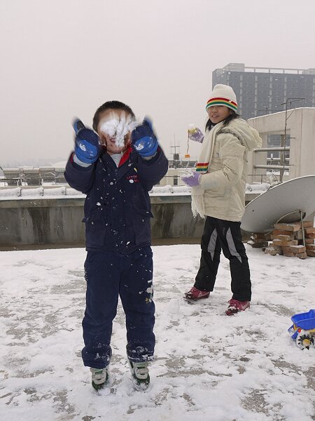 玩雪
雪不粘，堆不成雪人，语馨和映辰打了几下雪仗，弄得满身都是。照相的瞬间映辰把雪团扔起来，挡住了脸。
