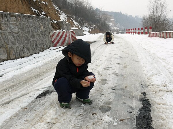 准备打雪仗
背阴的地方雪还在，映辰不顾冻手，要和语馨打雪仗。
