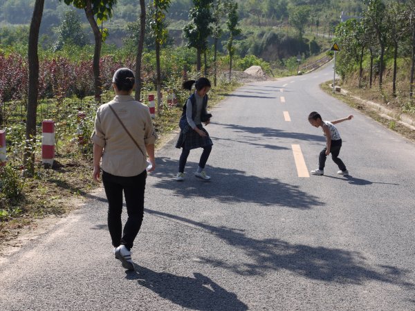 踩影子
这里没有沿湋河的步道，新修的旅游路没有什么车，语馨和映辰在玩踩影子的游戏。
