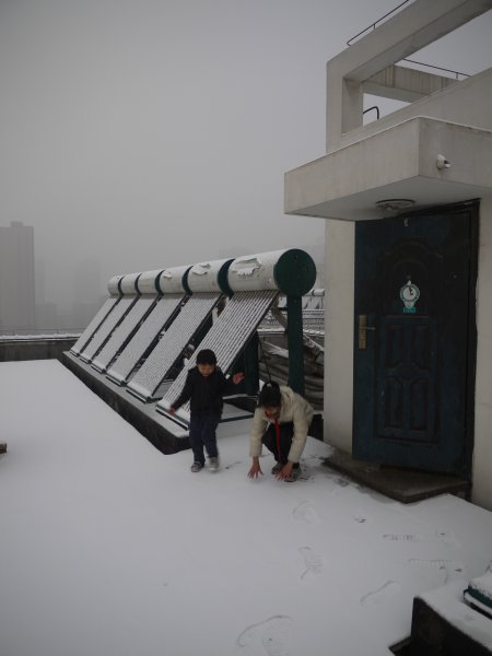 准备堆雪人
楼下的街道下面有供热管道，雪落下来就化了。楼顶就不一样了，积了厚厚的雪。
