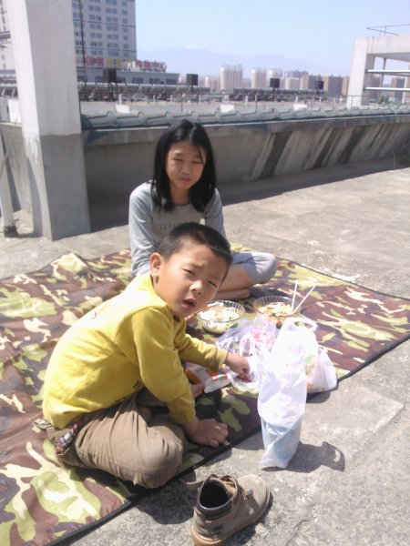 楼顶的野餐
五一下雨了，五二天气很好，但是语馨要学画画，只好在楼顶上野餐。远处可以看见太白山的主峰和积雪。
