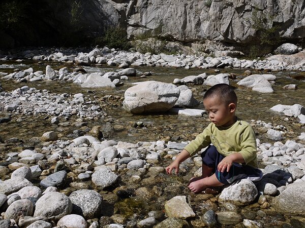 戏水
车沿着盘山道开了好一阵子，忽然发现旁边是连珠潭景区，景区大门外面是一条小溪，许多人在玩水，映辰和语馨也迅速地加入其中。
