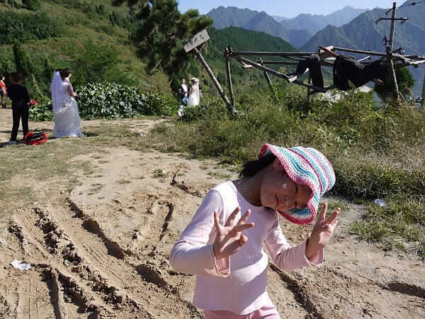 婚纱照
这里有好几拨照婚纱照的，后面是黑河金盆水库，景致很好，滑稽的是镜头以外就是仙游寺的生活垃圾和晒在木头杆子上的和尚的棉衣。随着摄影师喊“美女，歪一下头”，语馨也弄了个姿势。
