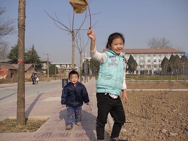 等妈妈吃饭
妈妈在楼里开会，姐弟俩在空旷的校园里玩，旁边的牡丹园一点生机也没有。
